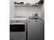 Functional laundry room with a modern washer and dryer set, a wire shelf, and organized storage for household essentials at 4962 Sweet Cedar Cir, Orlando, FL 32829