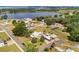 Wide aerial view showing houses in a neighborhood near a lake, and the home's green backyard with a pool at 501 Main St, Lake Hamilton, FL 33851