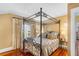 This bedroom features a four-poster bed, hardwood floors and natural light from the nearby window at 501 Main St, Lake Hamilton, FL 33851