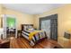 Comfortable bedroom with hardwood floors, yellow walls, and a queen sized bed at 501 Main St, Lake Hamilton, FL 33851