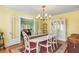 Well-lit dining room with a white table, seating for six, and a view into the living room at 501 Main St, Lake Hamilton, FL 33851