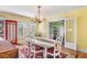 Bright dining room with a chandelier, a white table, and seating for six, adjacent to the living room at 501 Main St, Lake Hamilton, FL 33851