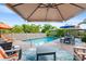 Inviting pool area with brick pavers, lounge chairs, coffee table and umbrellas at 501 Main St, Lake Hamilton, FL 33851