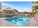 Inviting pool area with brick pavers, lounge chairs, and several umbrellas at 501 Main St, Lake Hamilton, FL 33851
