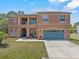 Inviting two-story home with a well-maintained lawn, blue garage, and front porch seating at 524 Nogales, Kissimmee, FL 34758