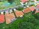 Birds-eye view displaying the home's tile roof, backyard with screened pool, and nearby pond at 530 Greenway Dr, Lake Wales, FL 33898