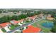 Community aerial view, with mature trees, showcasing home's tile roof and a nearby pond with fountain at 530 Greenway Dr, Lake Wales, FL 33898