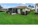 A well-maintained yard highlights the home's back exterior, featuring a screened-in porch area and manicured hedges at 530 Greenway Dr, Lake Wales, FL 33898
