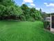 The expansive backyard features lush green grass and mature trees offering plenty of space for outdoor activities at 530 Greenway Dr, Lake Wales, FL 33898
