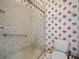 Bathroom with glass shower, commode and floral wallpaper at 530 Greenway Dr, Lake Wales, FL 33898