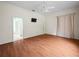 Large bedroom with hardwood floors, a ceiling fan, and a doorway to the bathroom at 530 Greenway Dr, Lake Wales, FL 33898