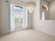 Bright dining area with tile flooring, a large window and sheer curtains, and a modern chandelier at 530 Greenway Dr, Lake Wales, FL 33898