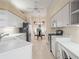 Well-lit kitchen featuring white cabinets, white appliances, and tile floors with a view to the breakfast nook at 530 Greenway Dr, Lake Wales, FL 33898