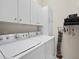 A laundry room with overhead cabinets and a full-size washer and dryer at 530 Greenway Dr, Lake Wales, FL 33898