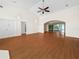 Spacious living room with hardwood floors, a high ceiling, ceiling fan, and large arched window at 530 Greenway Dr, Lake Wales, FL 33898