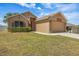 Lovely single-level home with a two-car garage, lush lawn, and an inviting front entrance and garden bed at 533 Ronshelle Ave, Haines City, FL 33844