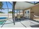Covered outdoor patio featuring a dining table and chairs adjacent to the sparkling pool at 533 Ronshelle Ave, Haines City, FL 33844