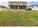A view of the house from the backyard features an enclosed patio at 5787 Dornich Dr, Auburndale, FL 33823