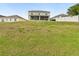A view of the house from the grassy backyard shows the patio at 5787 Dornich Dr, Auburndale, FL 33823