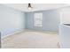Upstairs bedroom with neutral carpet, soft blue walls, and window offering natural light at 5787 Dornich Dr, Auburndale, FL 33823