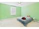 Bright bedroom featuring a ceiling fan, light green walls, and a large window at 5787 Dornich Dr, Auburndale, FL 33823