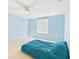 Bright bedroom featuring a ceiling fan, light blue walls, and a large window at 5787 Dornich Dr, Auburndale, FL 33823
