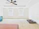 Large carpeted bedroom with fan, two windows, tv, and dog bed for comfort at 5787 Dornich Dr, Auburndale, FL 33823