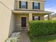 A close-up of the front door featuring a covered porch and a lush, manicured shrub at 5787 Dornich Dr, Auburndale, FL 33823