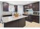 Kitchen island with granite countertop, dark cabinets and tile flooring at 5787 Dornich Dr, Auburndale, FL 33823
