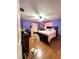Bedroom with purple walls, wood floors, and a large bed at 620 Se Oleander Se Dr, Winter Haven, FL 33880