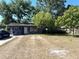 Charming single-story home with a cozy front porch, lush trees, and a driveway at 620 Se Oleander Se Dr, Winter Haven, FL 33880