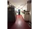 Kitchen with white cabinets, red floors, and ceiling fan at 620 Se Oleander Se Dr, Winter Haven, FL 33880