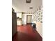 Kitchen features white cabinets, red floors, and ceiling fan at 620 Se Oleander Se Dr, Winter Haven, FL 33880