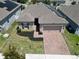 Aerial view of a well-maintained house with solar panels and brick driveway in a suburban neighborhood at 625 Disa Dr, Davenport, FL 33837