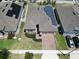 An aerial view shows this well-kept home with solar panels, landscaped yard and brick paved driveway at 625 Disa Dr, Davenport, FL 33837