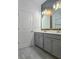 Bathroom featuring double sinks, brushed gold fixtures, and gray vanity at 625 Disa Dr, Davenport, FL 33837