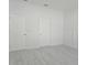 Neutral bedroom with wood-look floors, two doors, and white walls at 625 Disa Dr, Davenport, FL 33837