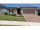 Charming single-story home featuring a brick driveway, manicured lawn and neutral color palette at 625 Disa Dr, Davenport, FL 33837