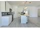 Open kitchen with a large island, stainless steel appliances, and wood-look tile flooring at 625 Disa Dr, Davenport, FL 33837