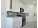 Bright kitchen with stainless appliances, mosaic backsplash, and white cabinets at 625 Disa Dr, Davenport, FL 33837