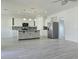 Bright open kitchen featuring gray wood floors, white cabinets, stainless steel appliances, and a tiled backsplash at 625 Disa Dr, Davenport, FL 33837