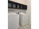 Well-lit laundry room with large capacity washer and dryer and shelf above at 625 Disa Dr, Davenport, FL 33837