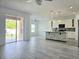 Open-concept living space with gray floors, an island kitchen, and sliding doors to the outdoor patio at 625 Disa Dr, Davenport, FL 33837