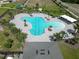 Aerial view of a large community pool, surrounded by lounge chairs and palm trees on a sunny day at 625 Disa Dr, Davenport, FL 33837