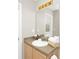 Bright bathroom with a sink, wood cabinets, and large mirror with vanity lighting at 662 Orista Dr, Davenport, FL 33897