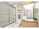 Nicely appointed bathroom with a shower-tub combo with sliding glass doors and wood cabinets at 662 Orista Dr, Davenport, FL 33897