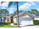 Charming single-story home featuring a 2-car garage, landscaped yard and a beautiful mature palm tree in the front at 662 Orista Dr, Davenport, FL 33897