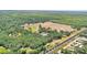 Aerial view of home in a rural setting surrounded by trees and featuring a railroad track at 6925 3Rd St, Mulberry, FL 33860
