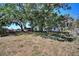View of the home's backyard with mature trees providing ample shade and privacy at 6925 3Rd St, Mulberry, FL 33860