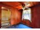 Cozy bedroom featuring wood paneling, ceiling fan, and window with natural light at 6925 3Rd St, Mulberry, FL 33860